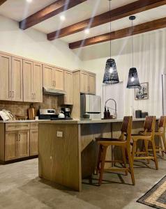 a kitchen with wooden cabinets and a kitchen island with chairs at Orion A 3BR Heated Pool with Desk and Laundry in Port Isabel