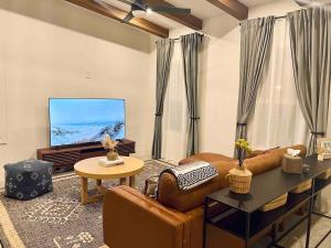 a living room with a couch and a flat screen tv at Orion A 3BR Heated Pool with Desk and Laundry in Port Isabel