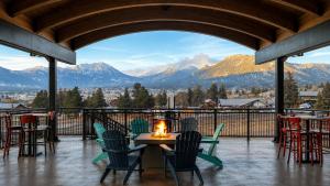 a table and chairs on a balcony with mountains at Expedition Lodge Estes Park at Rocky Mtn National Park in Estes Park
