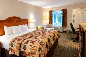 a hotel room with a bed and a window at Days Inn by Wyndham Apple Valley Pigeon Forge/Sevierville in Pigeon Forge