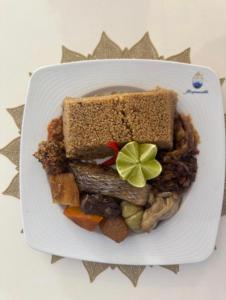 a plate of food with a sandwich and vegetables at RÉSIDENCE MAME DIARRA kl in Kaolack