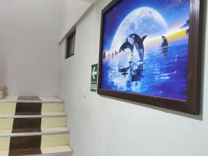 a tv hanging on a wall with dolphins in the water at Hostal Romances in Chimbote