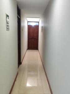 a hallway with a door and a tile floor at Hostal Romances in Chimbote
