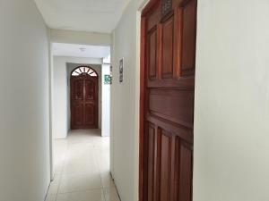 a hallway with a wooden door and a hallway with a hallwayngth at Hostal Romances in Chimbote