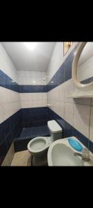 a bathroom with a toilet and a sink at Hostal Romances in Chimbote