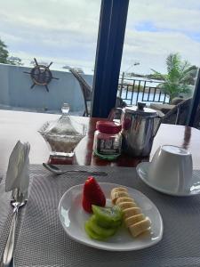 a plate of food with a strawberry and waffles on a table at Flightless Cormorant in Puerto Ayora