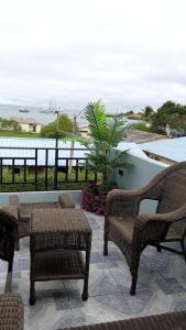 a patio with chairs and tables and a view of the ocean at Flightless Cormorant in Puerto Ayora