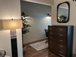 a bedroom with a dresser and a mirror at Downtown Suite with Balcony in Syracuse