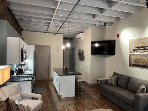 a living room with a couch and a kitchen at Downtown Suite with Balcony in Syracuse