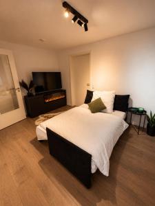 a bedroom with a large bed and a flat screen tv at Design Apartment 5 am Titisee mit Kamin, E-Ladestation, Balkon, Top Lage in Titisee-Neustadt