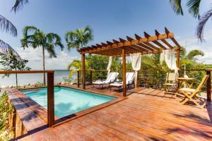 an outdoor deck with a pool and a pergola at Luxurious Lagoon Home w Elegant Decor & Pool in Maya Beach