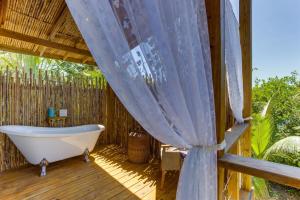 a bath tub on a deck with a curtain at Luxurious Lagoon Home w Elegant Decor & Pool in Maya Beach