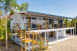 a house on the beach with a large deck at Luxurious Lagoon Home w Elegant Decor & Pool in Maya Beach