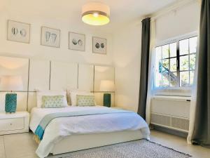 a white bedroom with a bed and a window at Luxury Casa da Fonte - Private Heated Salt Pool in Faro +26 photos