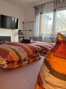 a bedroom with two beds and a flat screen tv at Ferienwohnung Zum Rottweiler Städtle - Erdgeschosswohnung in Rottweil