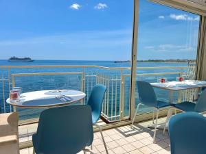 a balcony with tables and chairs and a view of the ocean at Nina B&B in Giardini Naxos