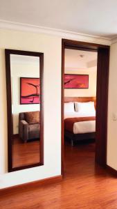 two mirrors in a room with a bed and a couch at Hotel American Blessing in Bogotá +3 photos