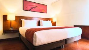 a bedroom with a large bed in a hotel room at Hotel American Blessing in Bogotá