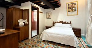 a bedroom with a bed and a dresser and a mirror at Hotel Posada Casa de la Tía in Oaxaca City
