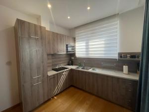 a kitchen with wooden cabinets and a sink and a window at Apartments Krug in Budva +110 photos