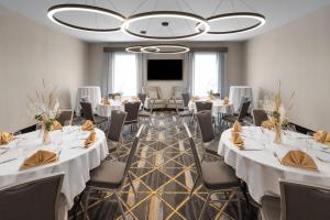 a conference room with tables and chairs and a projection screen at Holiday Inn Midland by IHG in Midland