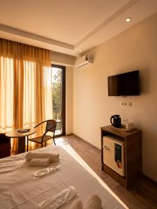a hotel room with a bed and a tv on the wall at Chill Kobuleti in Kobuleti