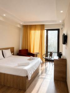 a bedroom with a large white bed and a couch at Chill Kobuleti in Kobuleti +13 photos