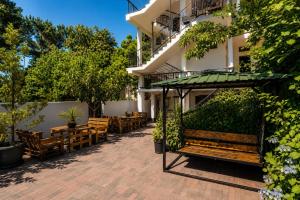 a patio with wooden benches and tables in front of a building at Chill Kobuleti in Kobuleti