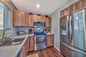 a kitchen with wooden cabinets and stainless steel appliances at Tahoe Retreat on the Meadow- Hot Tub AC in South Lake Tahoe