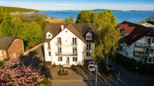 an aerial view of a large white house with the water at Oceanview Residences Lauterbach Rügen Ostsee erste Reihe in Putbus