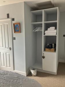 a bedroom with a closet with white shelves and a door at Hillhead Farm Bed and Breakfast in Cullompton