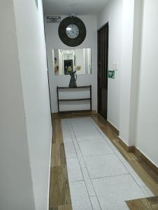 a hallway with a clock on the wall and a mirror at APARTAMENTOS Don GUILLE in Santa Rosa de Cabal