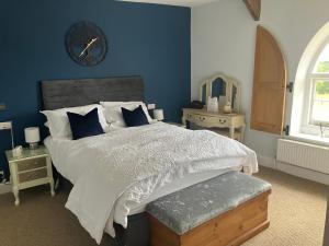 a bedroom with a large bed and a clock on the wall at Hillhead Farm Bed and Breakfast in Cullompton