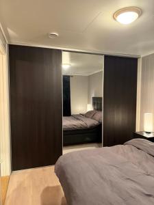 a bedroom with two beds and a large mirror at Lux Apartment Gravdal in Gravdal
