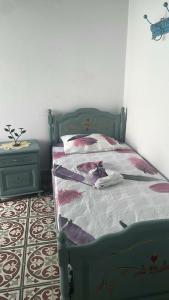 a bedroom with a green bed and a night stand at Beit Emna2 in Kairouan
