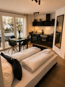 a living room with a bed and a dining room at Design Apartment 5 am Titisee mit Kamin, E-Ladestation, Balkon, Top Lage in Titisee-Neustadt