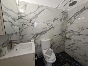 un bagno con un WC bianco e un lavandino di Babis a Città di Skiathos