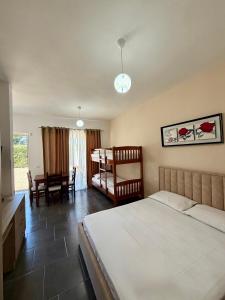 a bedroom with a bed and a table and chairs at "Seaside Pines" Apartments in Vlorë