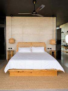 a bedroom with a wooden bed with white sheets at AGV II Cayo View in Monte Rojo