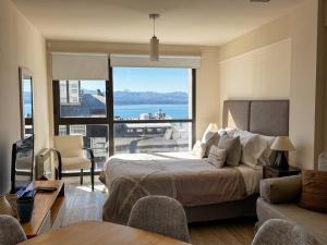 a bedroom with a bed and a view of the ocean at URBANA SUITES & STUDIOS 440 in San Carlos de Bariloche