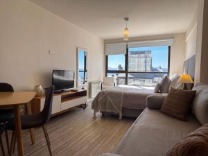 a bedroom with a bed and a desk with a television at URBANA SUITES & STUDIOS 440 in San Carlos de Bariloche