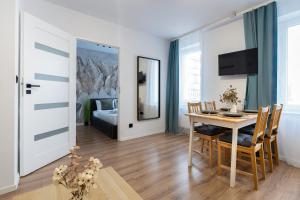 a living room with a table and a dining room at HostLoop Apartments - Świętego Pawła 10 in Katowice
