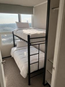 a bunk bed in a room with a window at Plaza Cervante II in Santiago