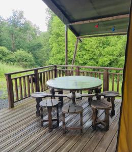 a table and chairs on a wooden deck at Puy Rond Camping in Bressuire