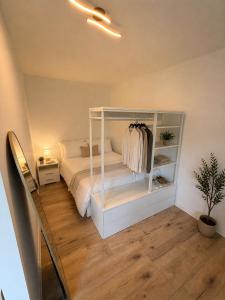 a bedroom with a white bed and a shelf at Moderne Terrassenwohnung mit privatem Eingang in Ennepetal