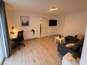 a living room with a couch and a desk at Moderne Terrassenwohnung mit privatem Eingang in Ennepetal