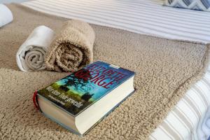 a book sitting on a bed next to a towel at Suites By The River in Ferragudo +56 photos