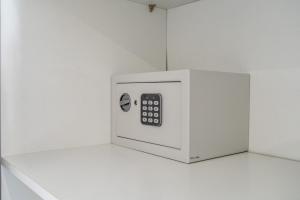 a white microwave with a remote control sitting on a counter at Suites By The River in Ferragudo