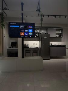 a kitchen with a large television in a room at Studio 44 Luxo Design Com Closet, Office e Ar in Mogi das Cruzes