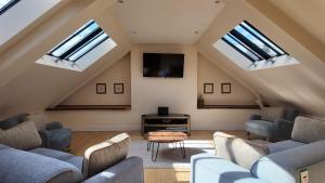 a attic living room with skylights and a tv at The Coach House in Alyth